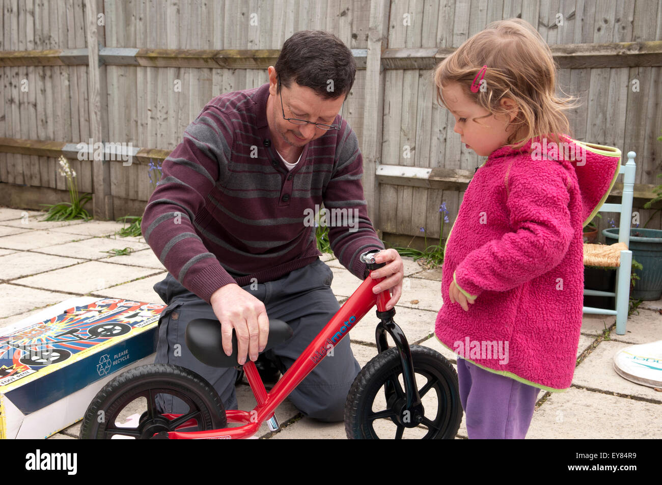 Little girl looking at her new balance bike, birthday present from her  grandfather Stock Photo - Alamy
