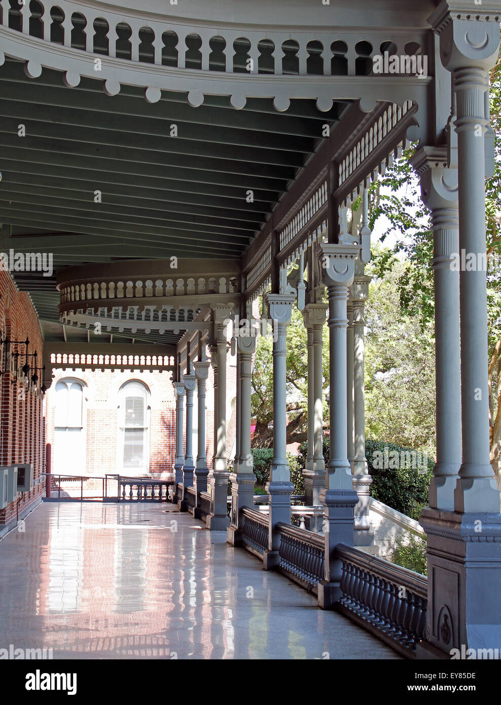 A walkway, showcasing Victorian architecture, shimmers in reflected light at the Henry B. Plant museum in Tampa, FL Stock Photo