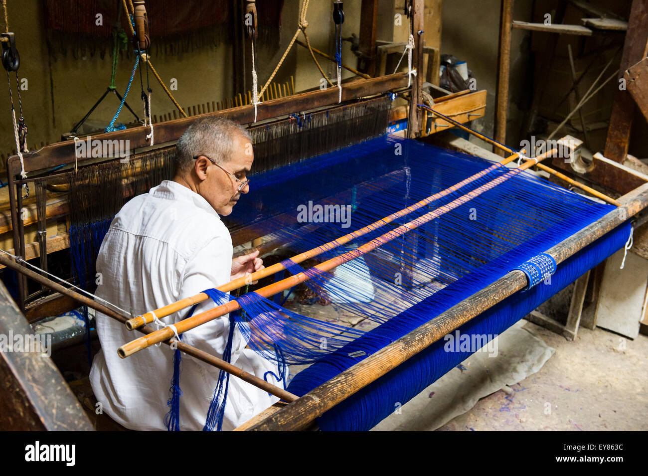Man working on a loom in the historic centre, Fez el Bali, Fes, Morocco Stock Photo