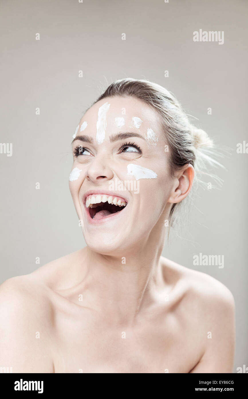 Young woman with streaks of lotion on face Stock Photo