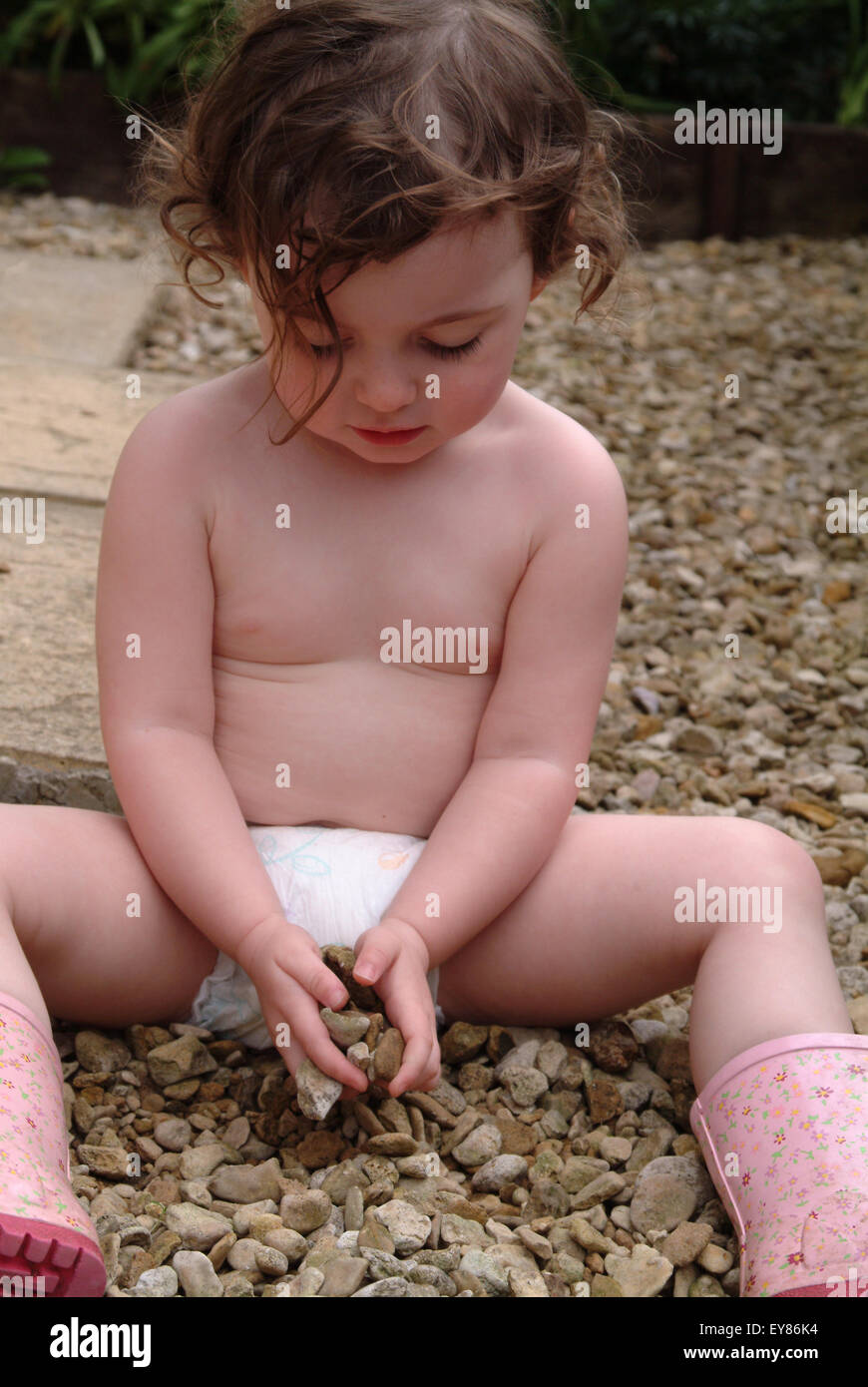 naked little kids  Naked little girl wearing a nappy playing with gravel on footpath Stock  Photo - Alamy