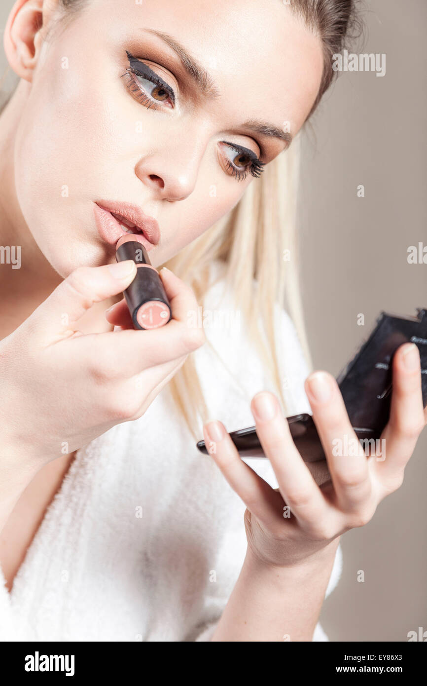 Young woman applying lipstick Stock Photo