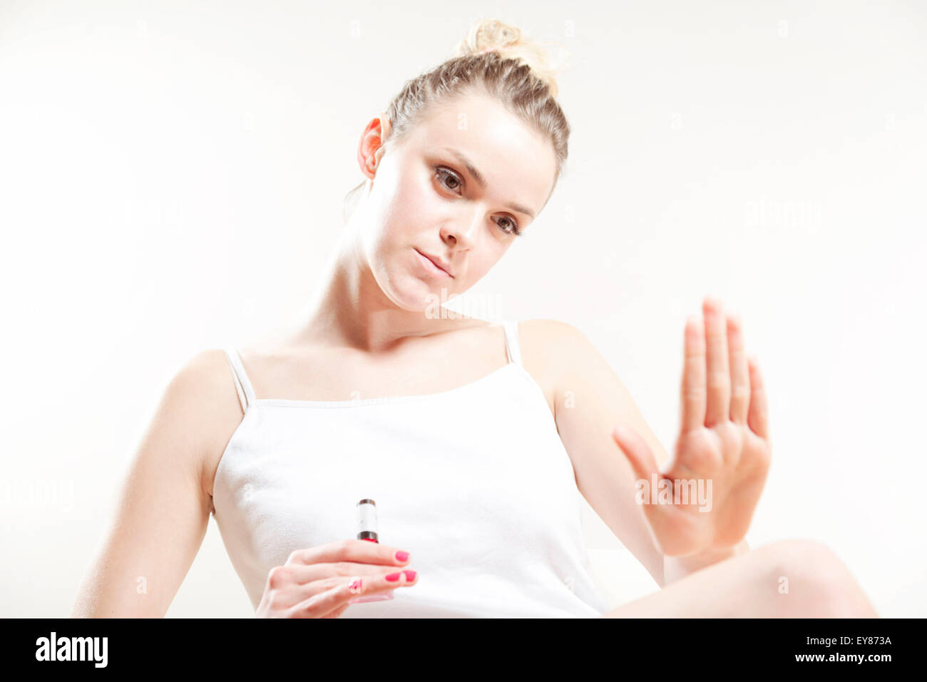 Young woman examining her fingernails Stock Photo