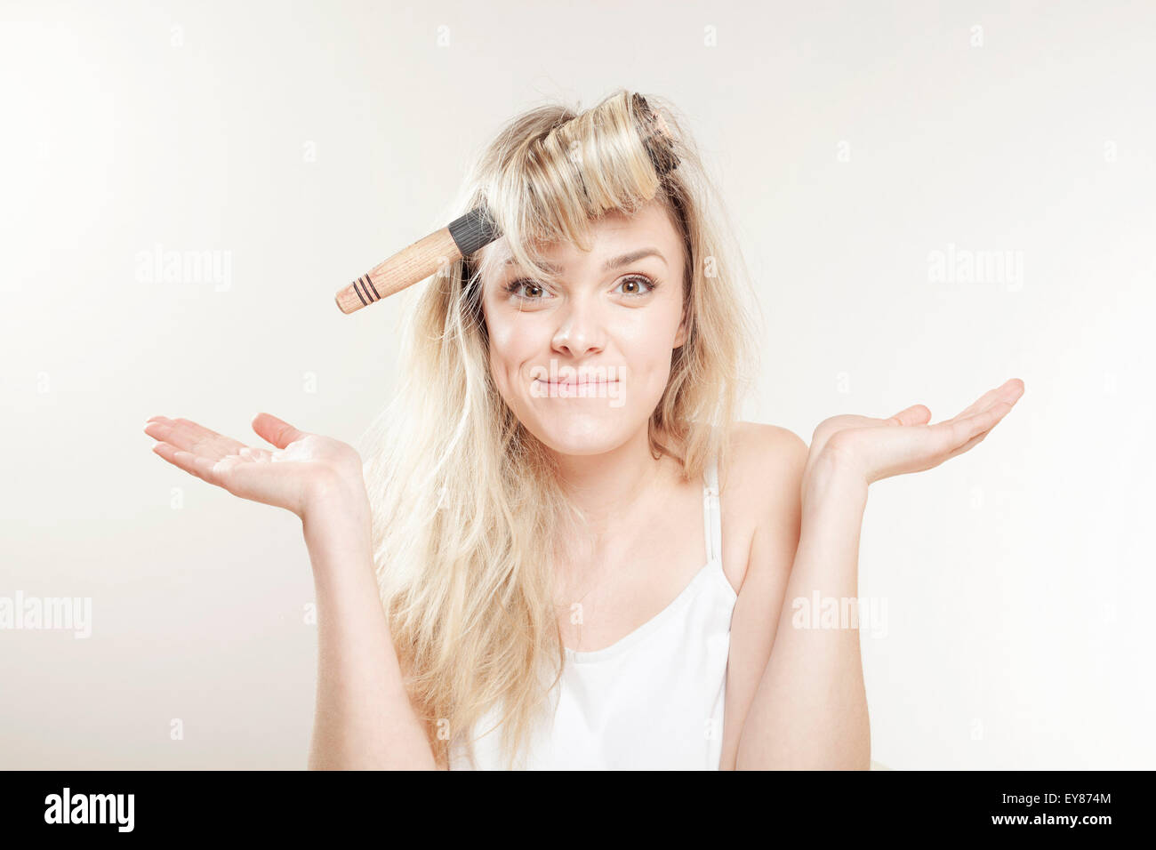 Young woman with hairbrush fooling around Stock Photo
