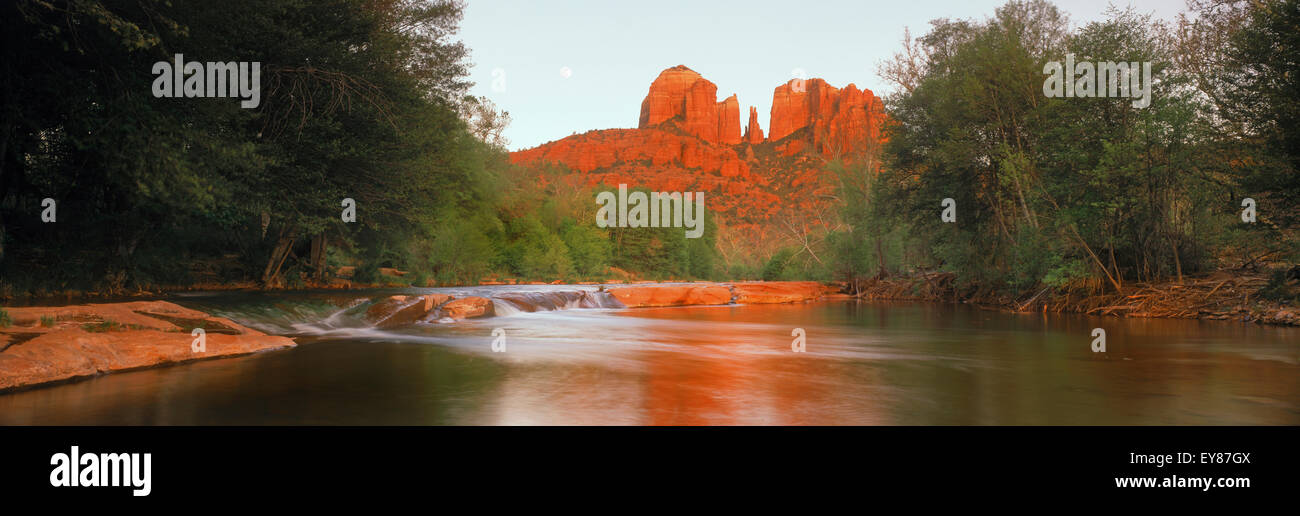 Panoramic shot of Cathedral Rock reflecting sunset light across Oak Creek in Sedona, Arizona Stock Photo