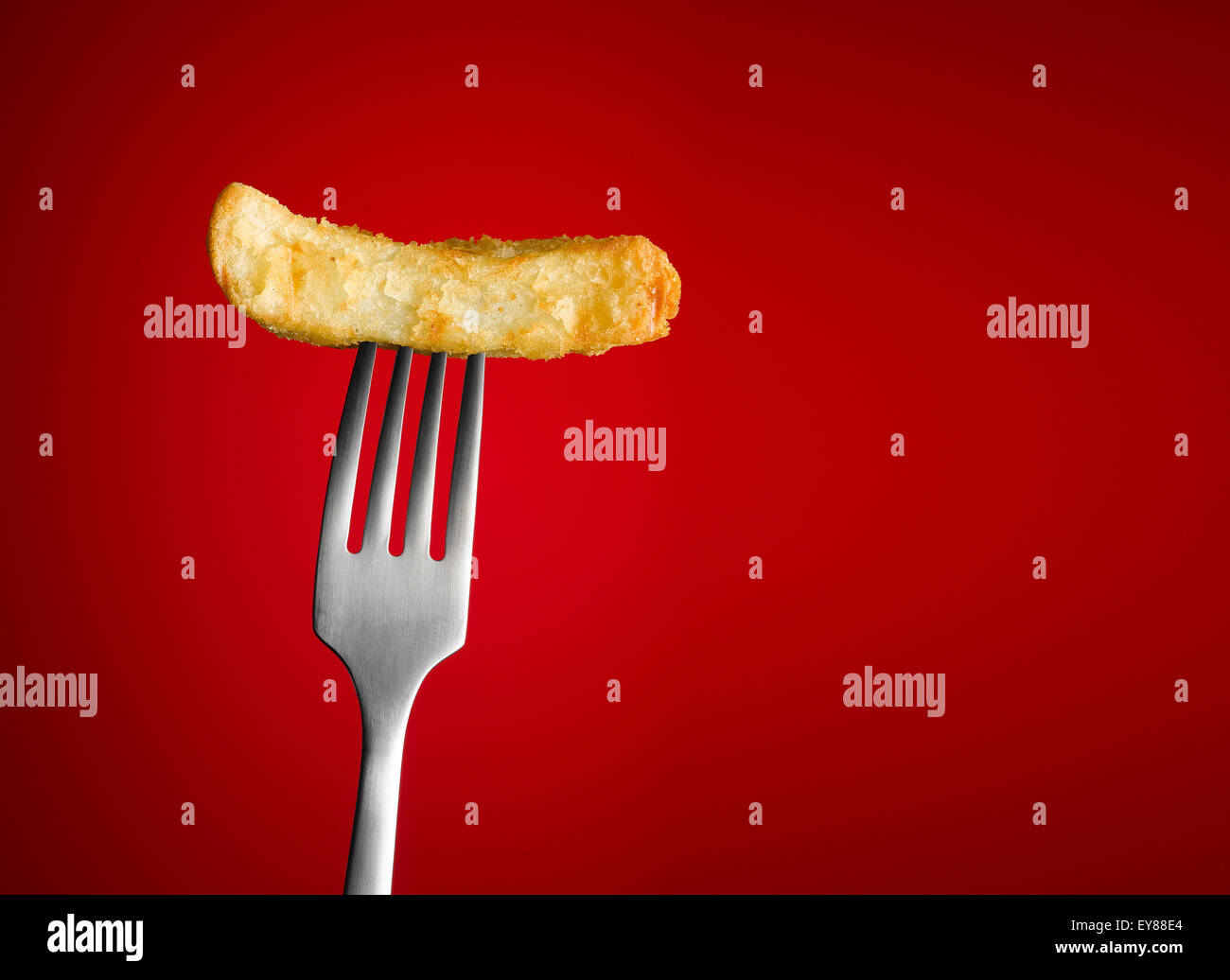 Chip on silver Fork with a red background Stock Photo