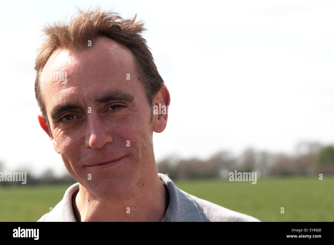 Portrait of a man with receding hairline, looking at camera smiling Stock Photo