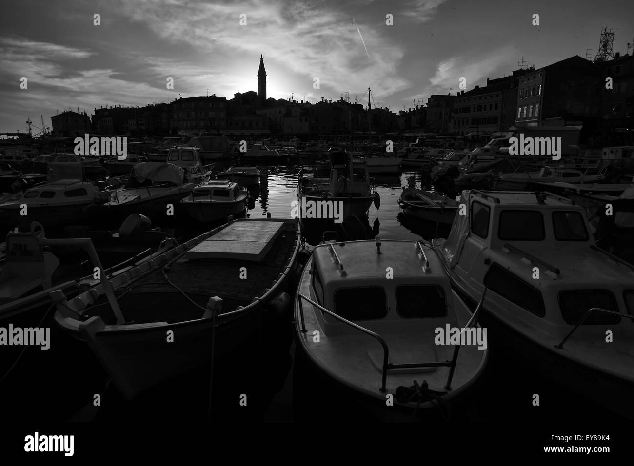 A view of the boats moored in the marina and the town with the Saint Euphemia bell tower at sunset in Rovinj, Croatia. Stock Photo
