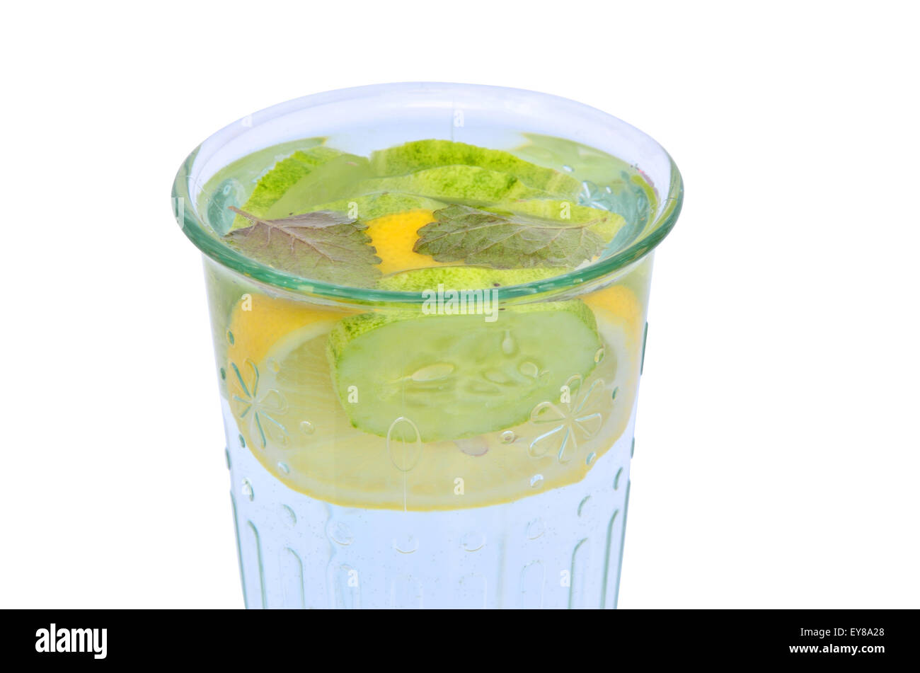 Glass of water with slices of lemon, cucumber and ginger set isolated on white plate Stock Photo