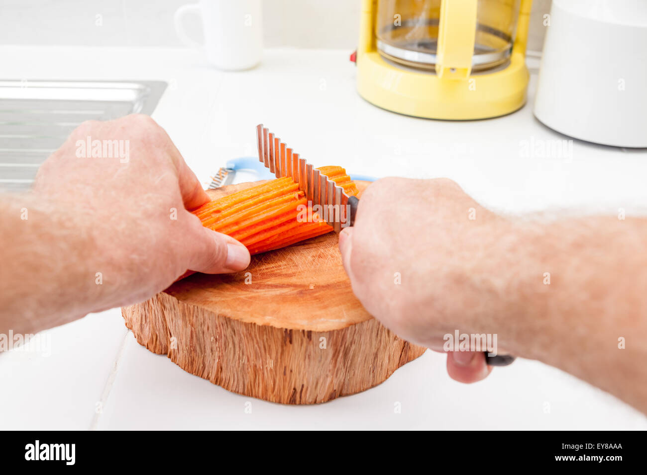 in the kitchen, I peel a carrot into pieces to be cut with a serrated
