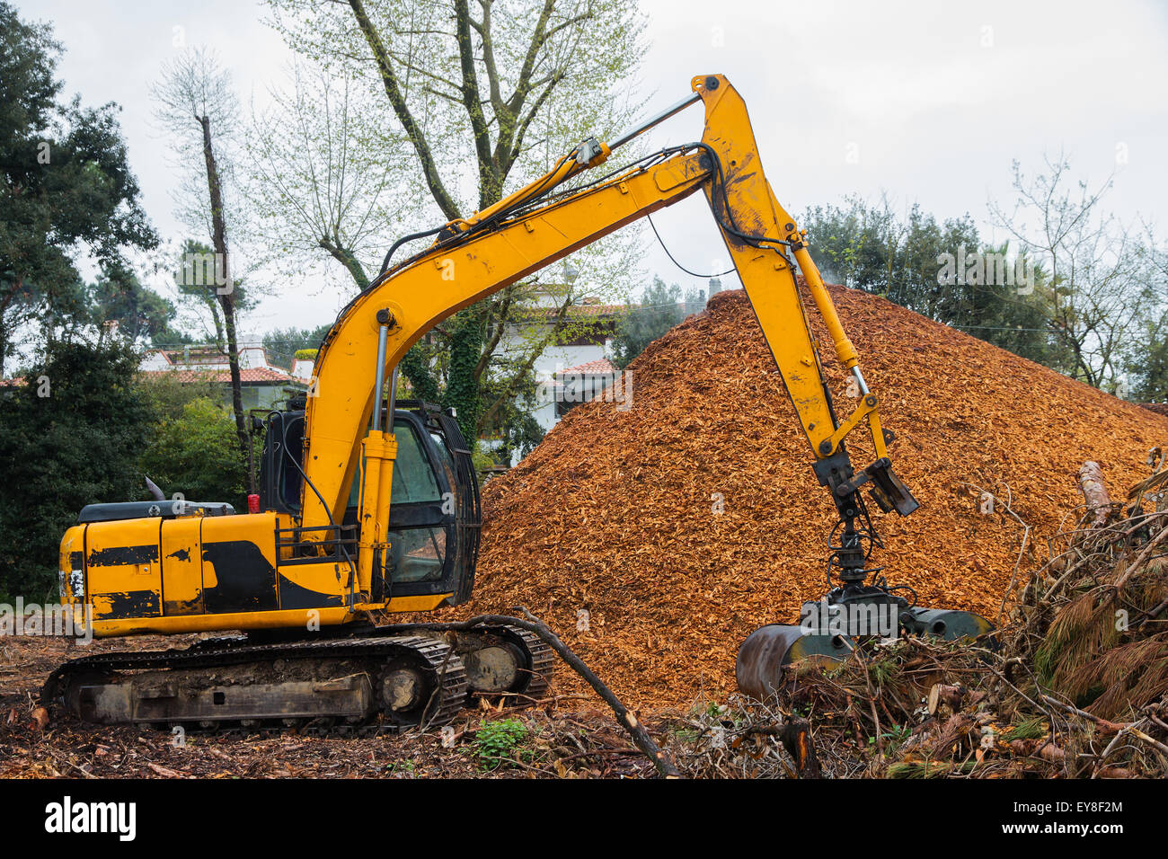 Tracked Excavator with hydraulic Clamshell Grab Bucket loader  used to move wood chips Stock Photo