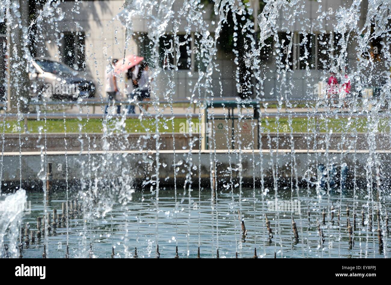 (150724) --YINCHUAN, July 24, 2015 (Xinhua) -- People walk past a fountain in Yinchuan, capital of northwest China's Ningxia Hui Autonomous Region, July 24, 2015. The Ningxia Weather Station issued a yellow alert for high temperature on Friday as the highest temperature in some parts of Ningxia is expected to reach 35 degrees Celsius in the next three days. (Xinhua/Peng Zhaozhi) (yxb) Stock Photo
