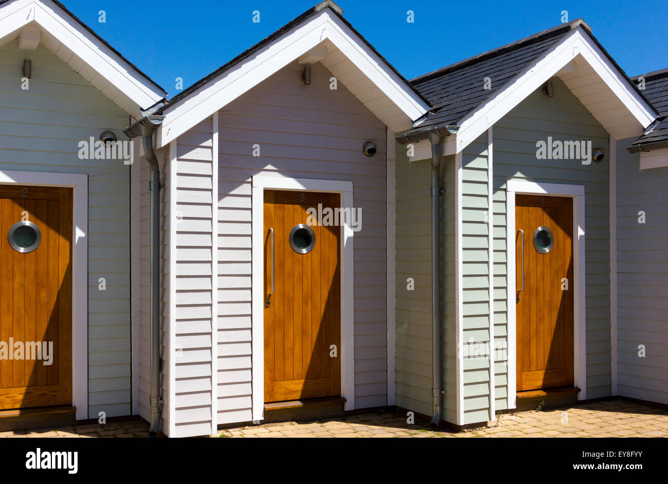 Wooden Doors - Front Entrances to Row of Modern Beach Huts, Shaldon Devon. Stock Photo