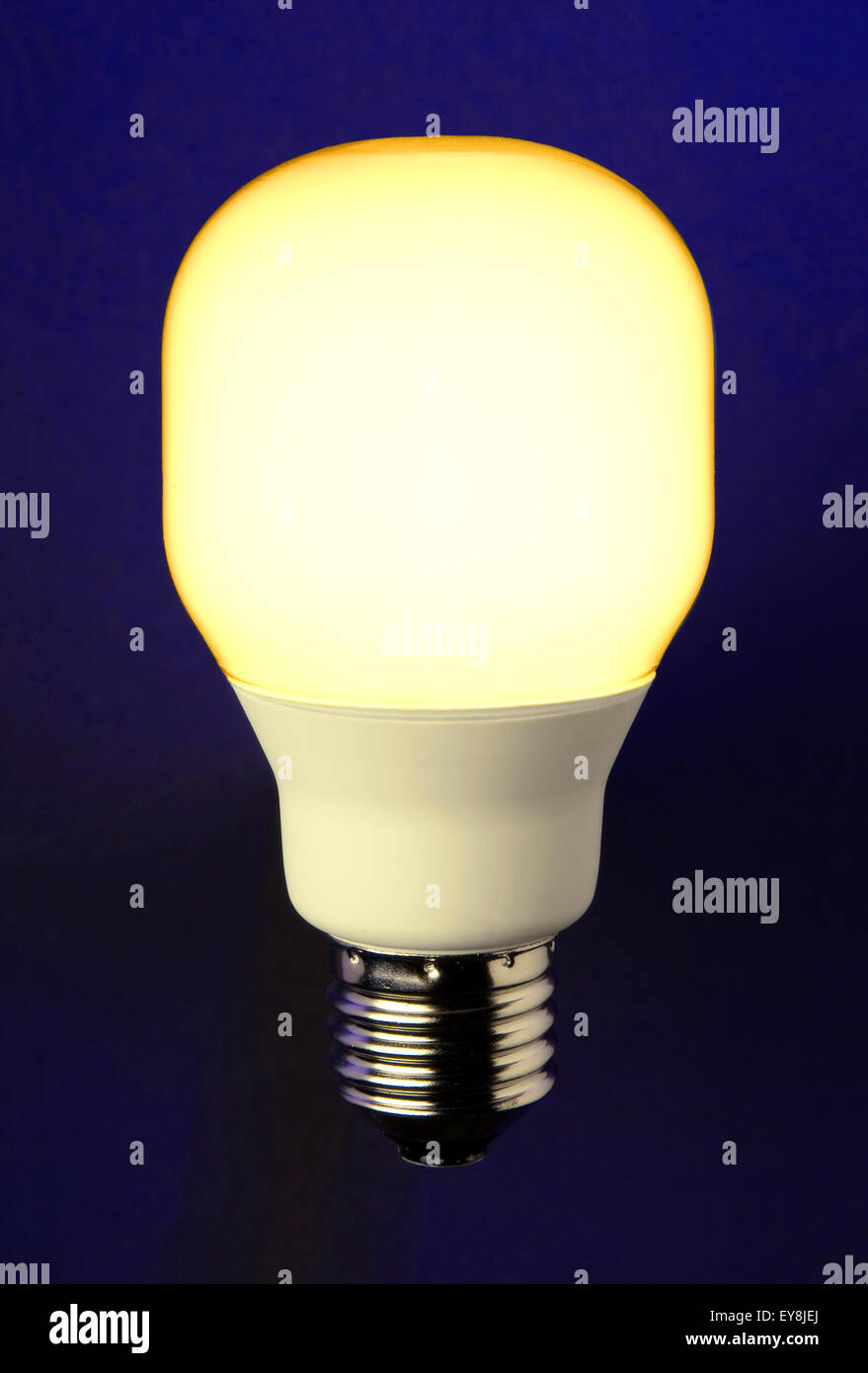 Energy saving lamp in front of blue background Stock Photo - Alamy