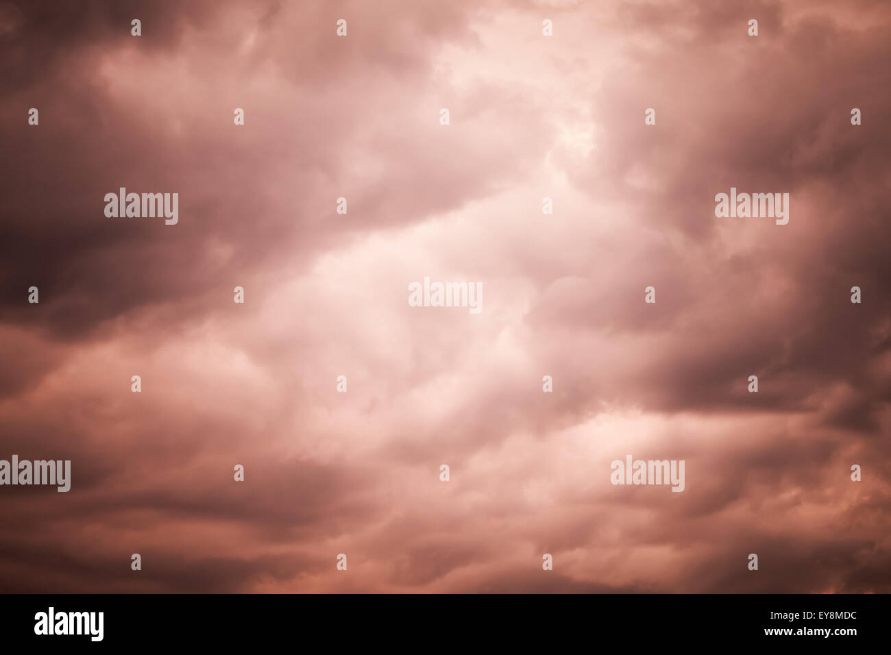 Dark red moody stormy clouds, natural sky background photo texture with tonal correction effect Stock Photo