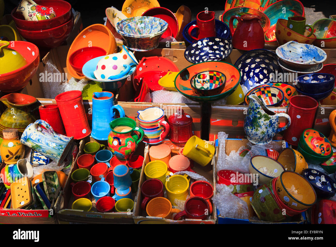 Display of colourful pottery cups jugs and dishes on a French market stall Stock Photo