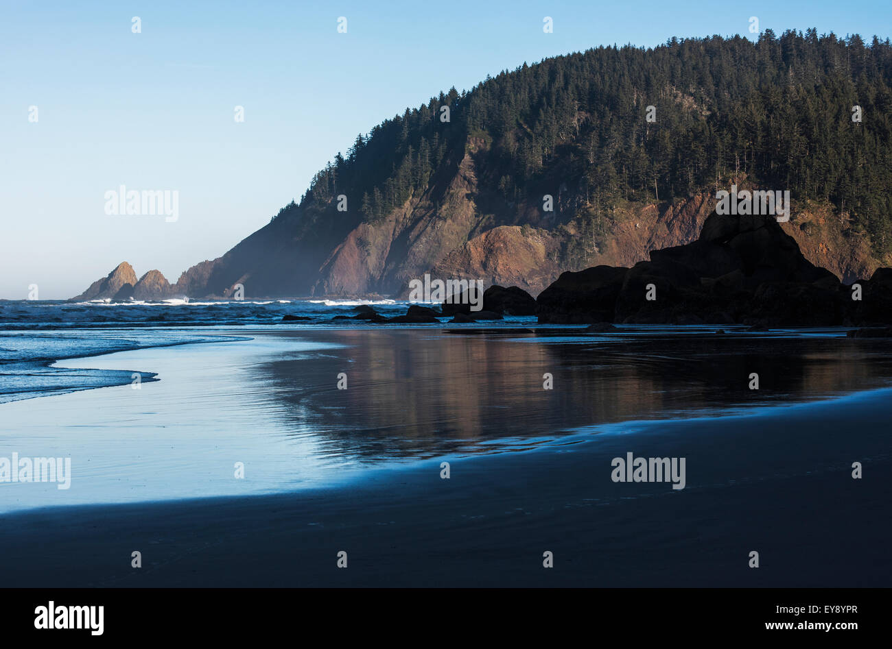 Morning sunlight warms Tillamook Head; Cannon Beach, Oregon, United