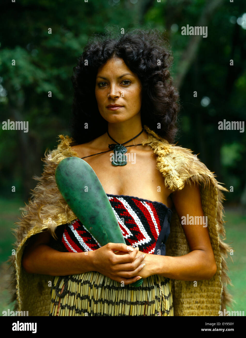 New Zealand Maori Woman In Traditional Dress Wearing Cloak And Piupiu Skirt Holding Pounamu Mere Stock Photo