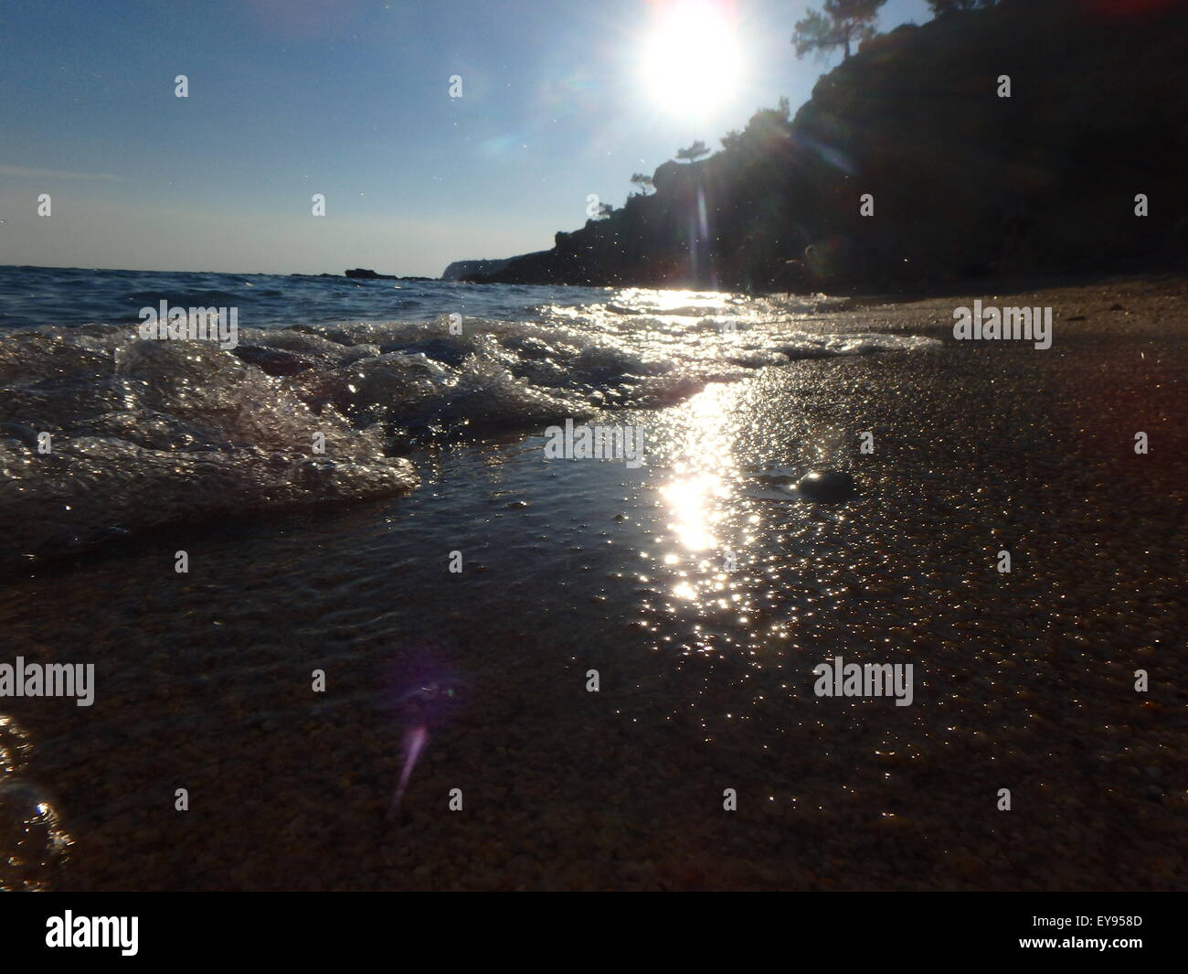 Small waves splashing in shallow waters at sunset. Stock Photo