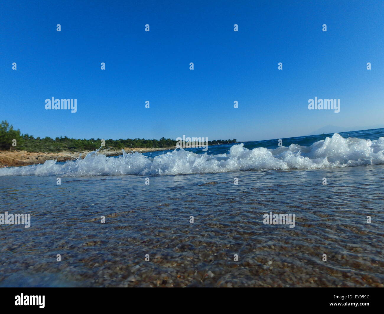 Small waves splashing in shallow waters at sunset. Stock Photo