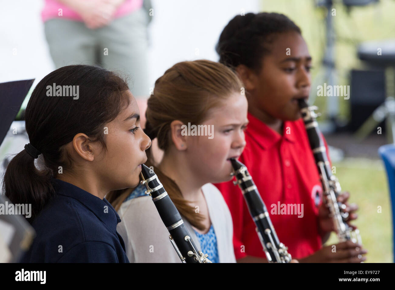 Three female clarinet players of various ethnicities (black African, Asian, white) play in  a youth music group / orchestra / band Stock Photo
