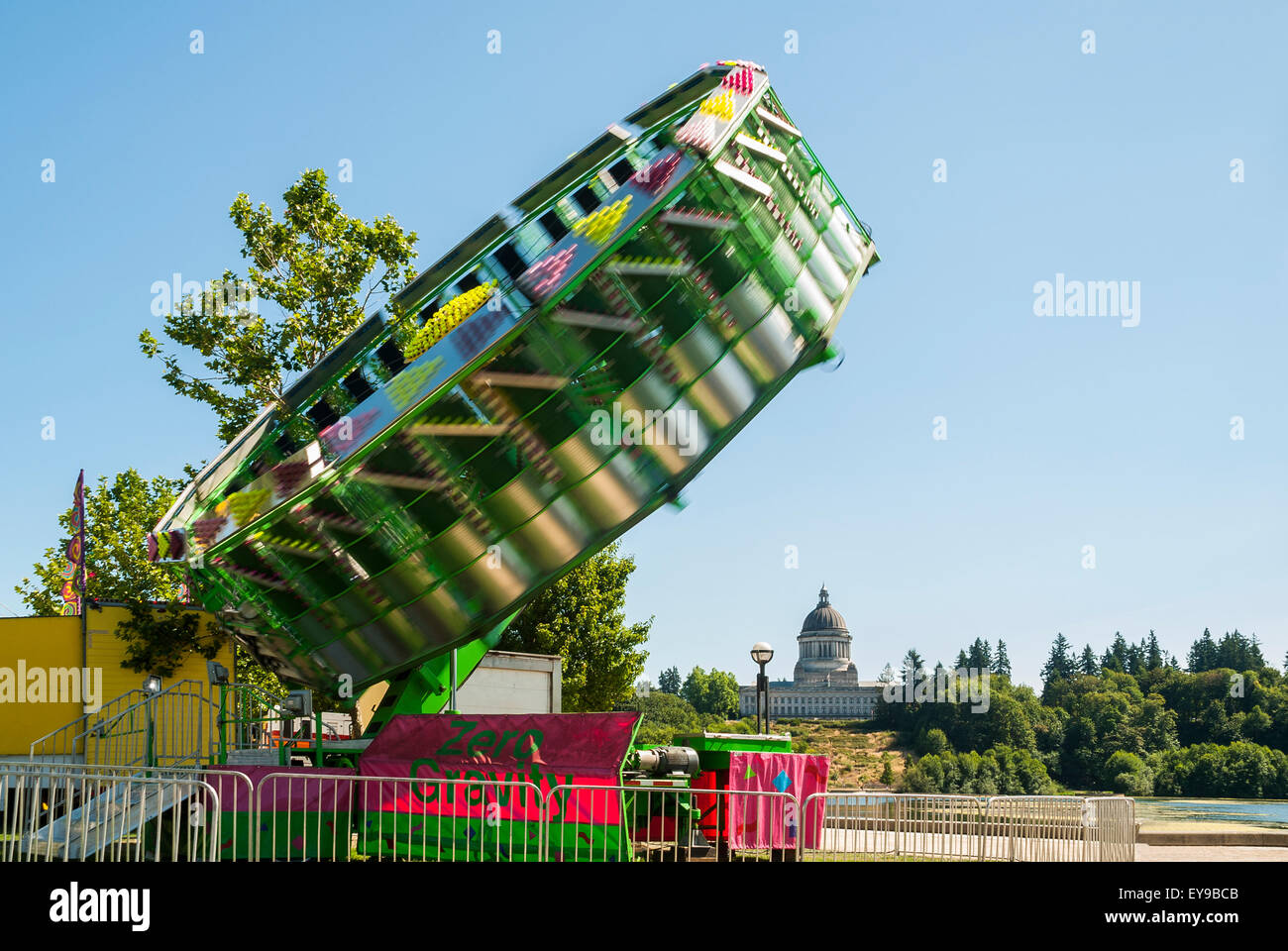 Ride that tilts and whirls riders in foreground with Olympia ...