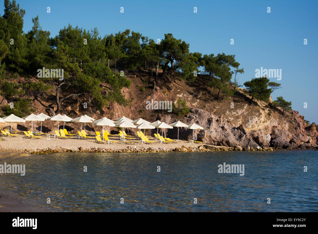 Thassos island, Greece, June 23, 2015: Nice organized beach Rosos Gremos with yellow sunbeds and umbrellas and crystal clear sea Stock Photo