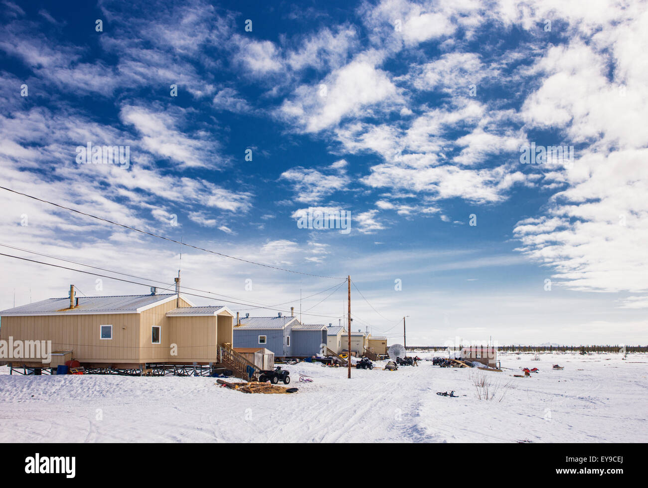 New housing units and power lines along a snowcovered street in Noatak
