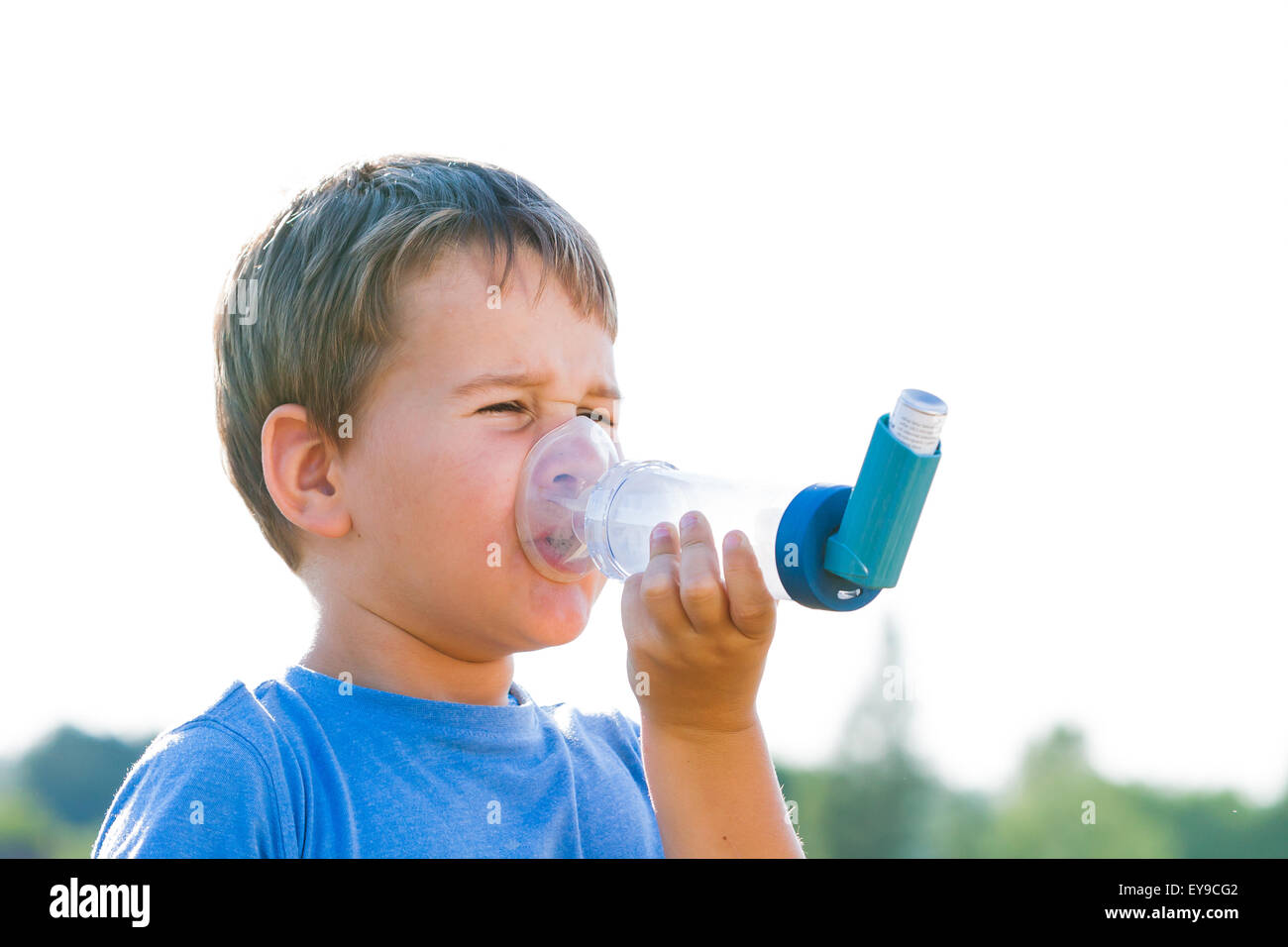 Boy using inhaler for asthma in village with summer sunset Stock Photo ...