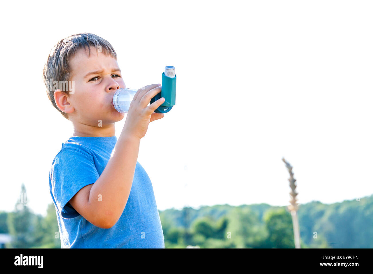 Boy using inhaler for asthma in village with summer sunset Stock Photo ...