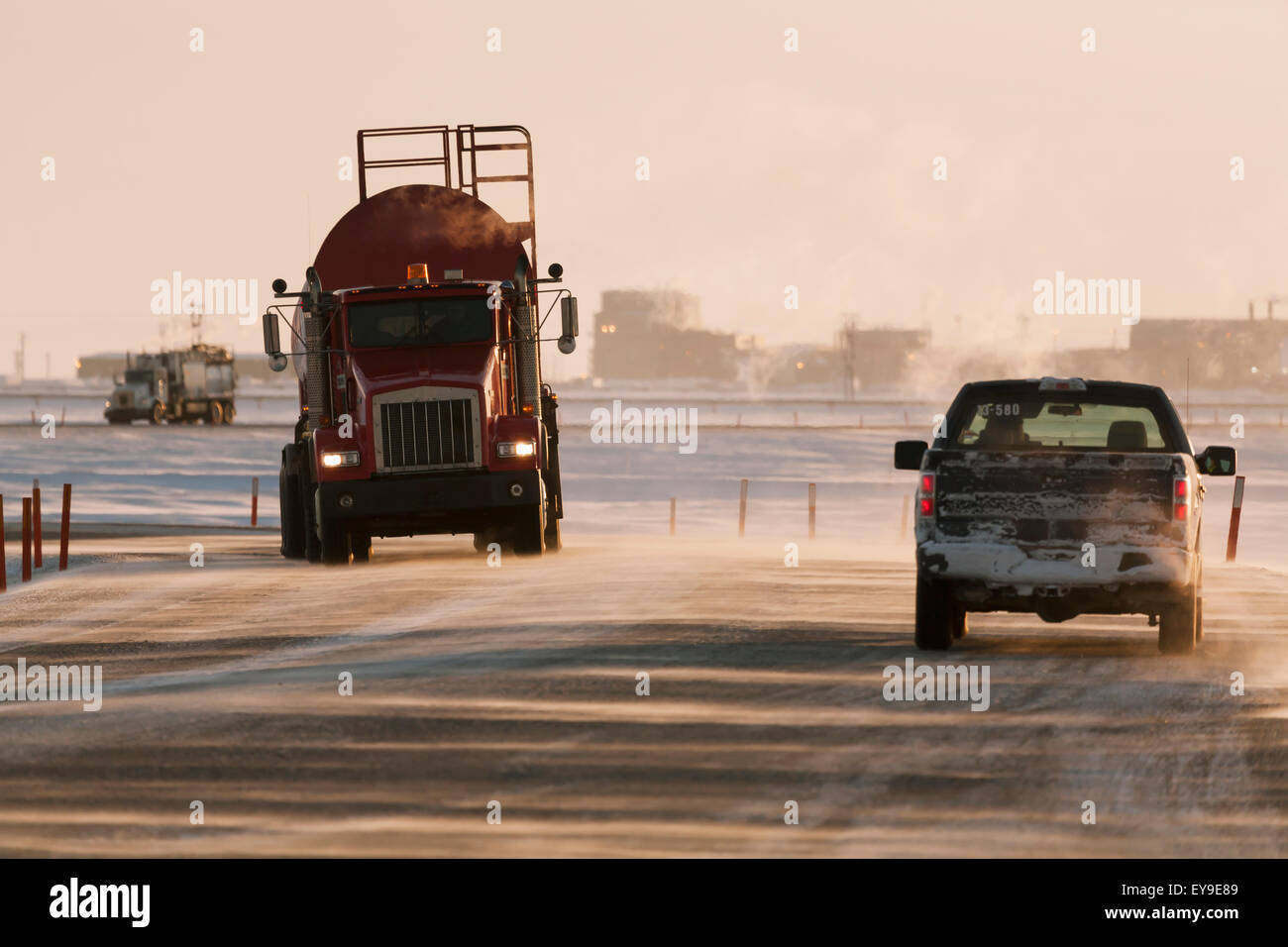 Vac truck and pickup truck driving on icy roads in the Prudhoe Bay Oil Field, Arctic Alaska, Winter Stock Photo