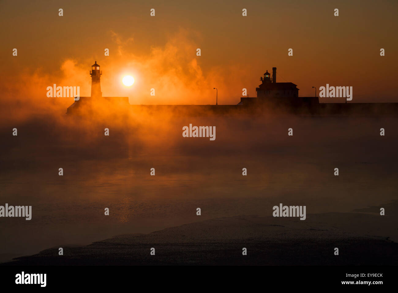 Sea smoke over Lake Superior and the Canal Park Lighthouse at sunrise; Duluth, Minnesota, United States of America Stock Photo