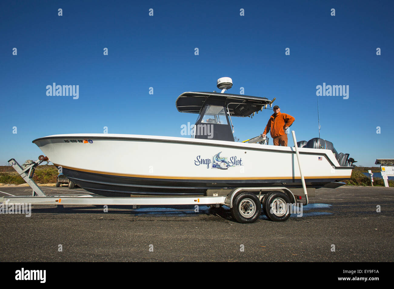 Man standing in his boat on a trailer; Montauk, New York, United States of America Stock Photo
