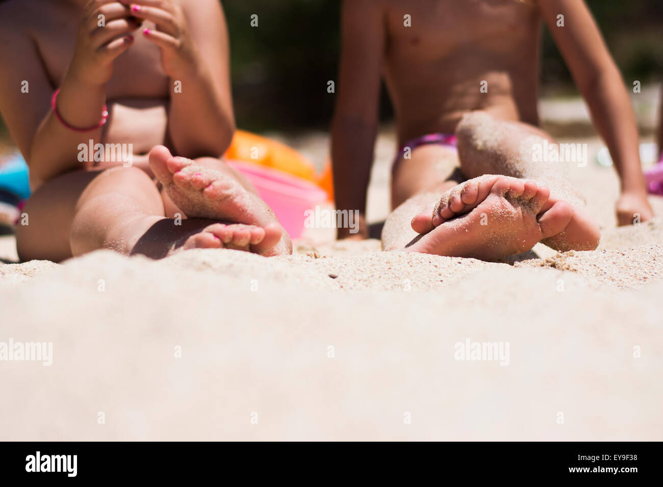 Children having fun spending their time on beach barefoot enjoying sand Stock Photo