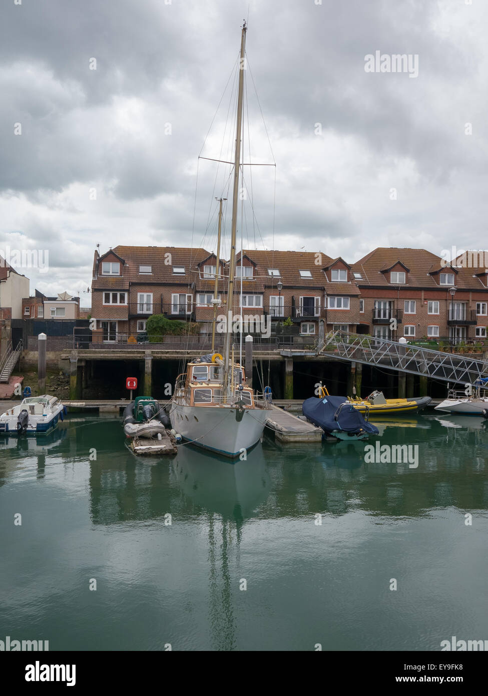 A leisure sailing boat moored in a private mooring beside housing at camber docks, Old Portsmouth, England Stock Photo