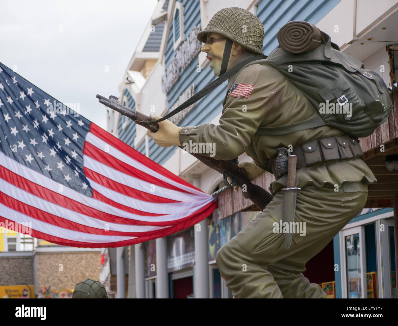 A model of a WW2 American soldier in battle uniform standing in front of an American flag Stock Photo