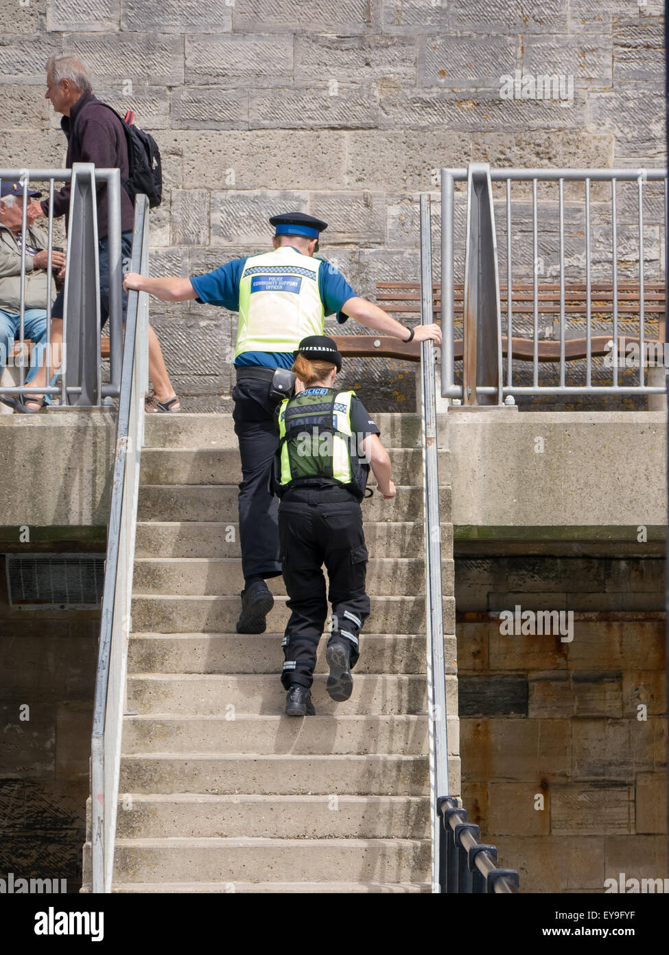 A Police community support officer and a police lady climbing stairs whilst on patrol Stock Photo