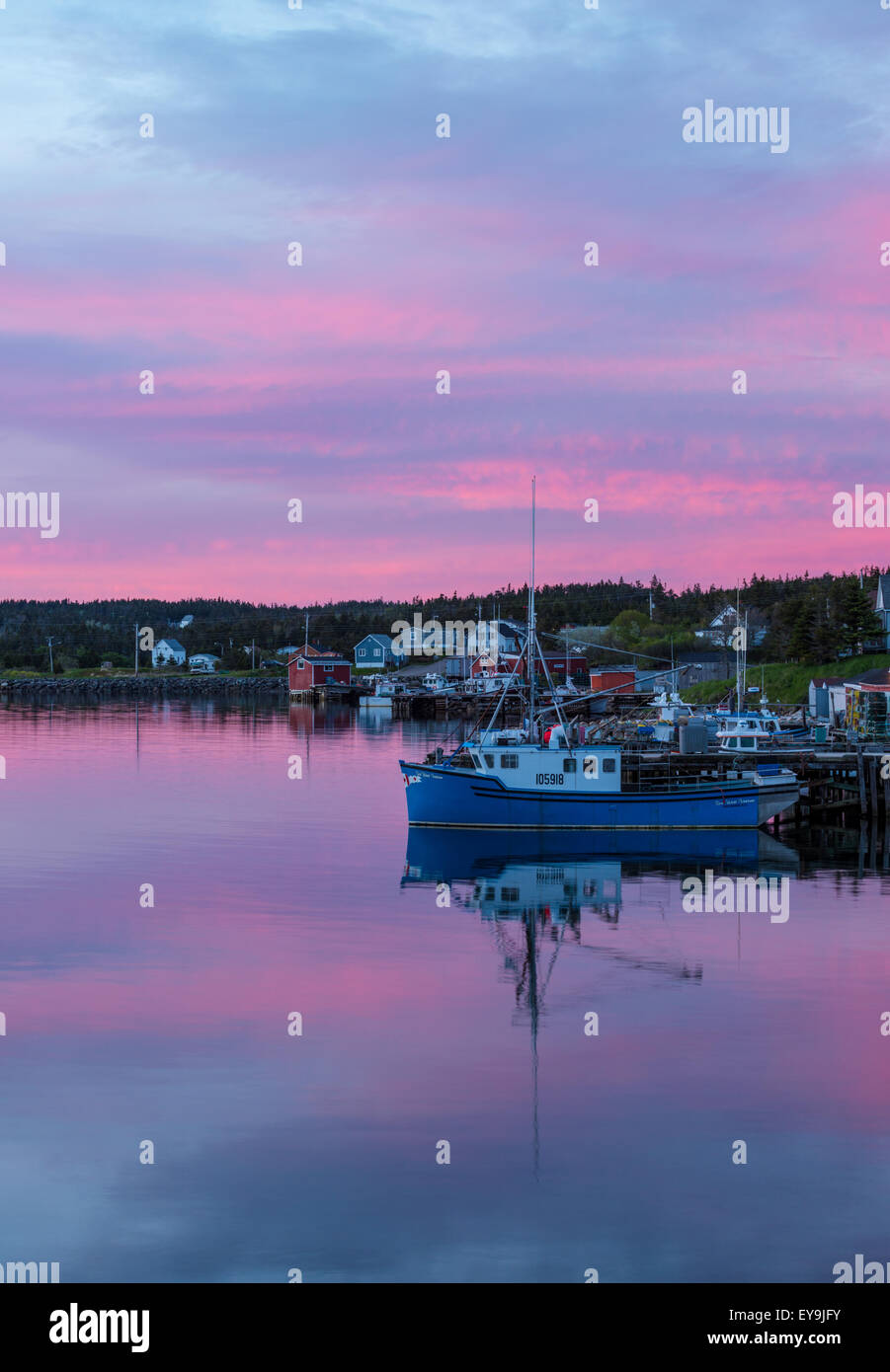 Pink sky over Louisbourg harbor at sunset, Louisbourg, Nova Scotia, Canada - Stock Image