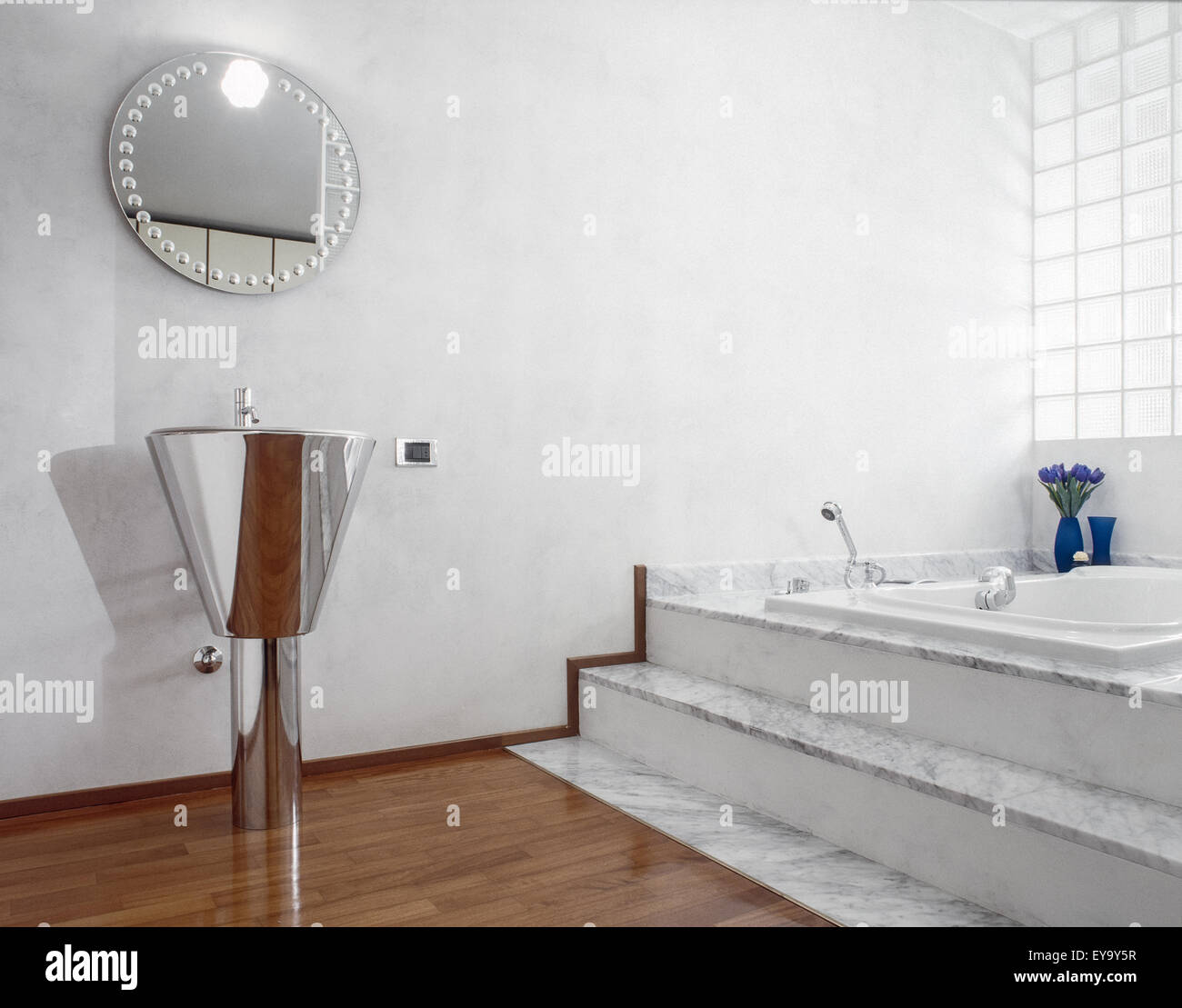 interior view of modern bathroom with steel washbasin and wood floor and glass block Stock Photo