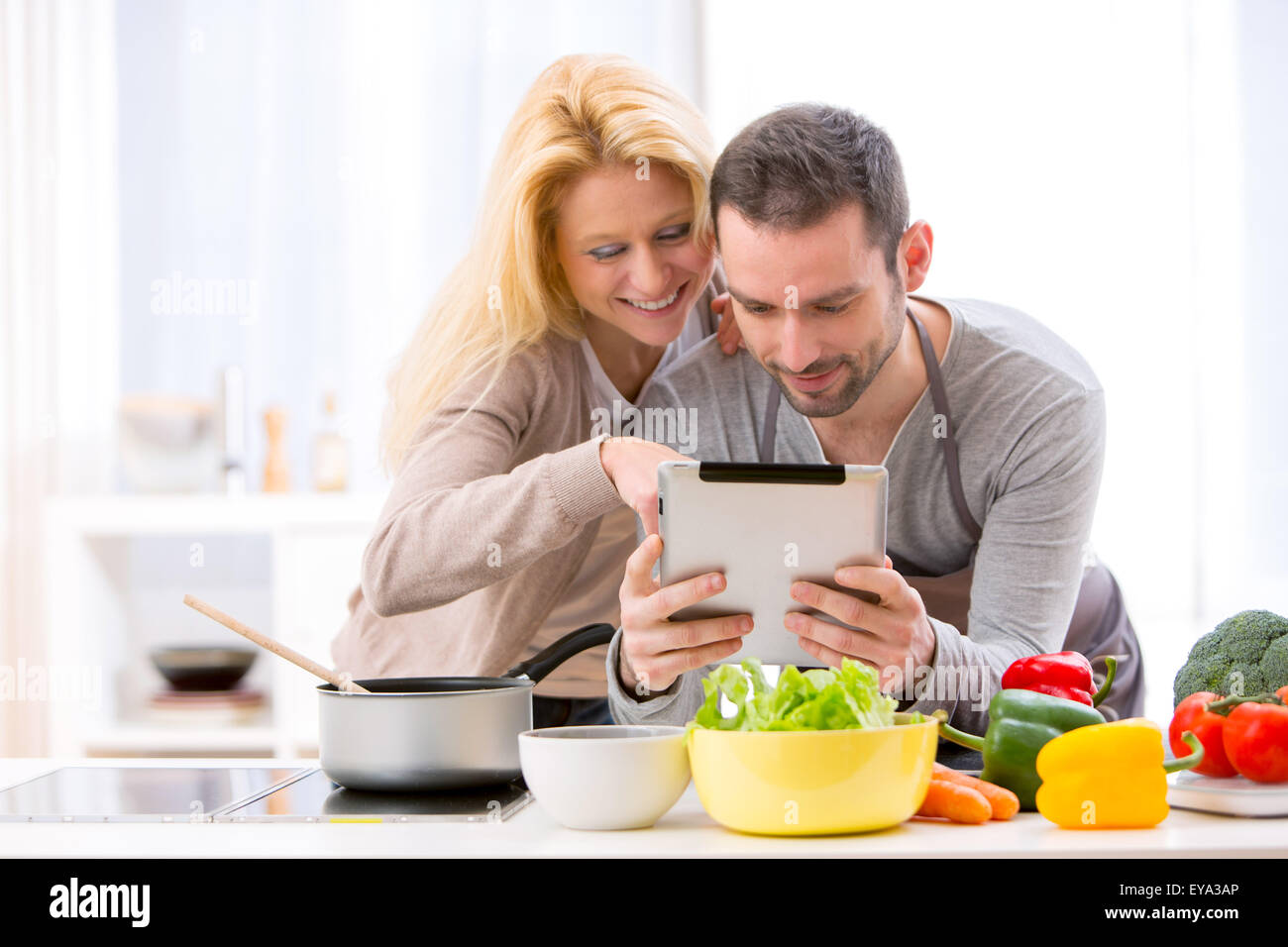 View of a Young attractive couple reading recipe on a  tablet Stock Photo