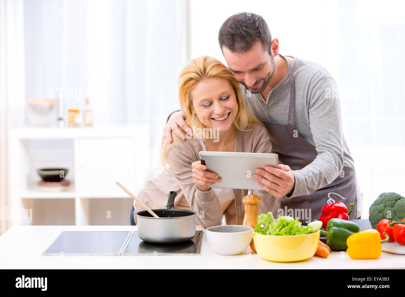 View of a Young attractive couple reading recipe on a  tablet Stock Photo
