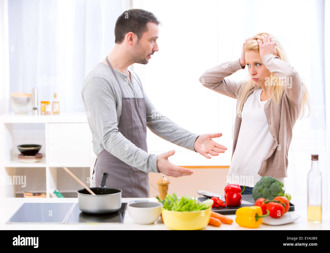 View of a Young attractive couple having an argue while cooking Stock Photo