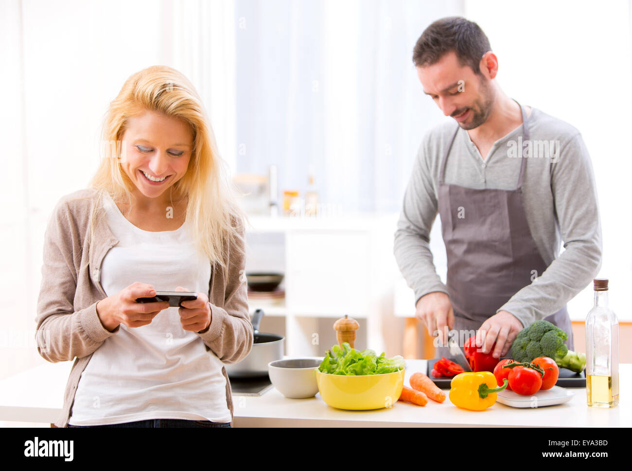View of a Young attractive woman writing text in kitchen Stock Photo