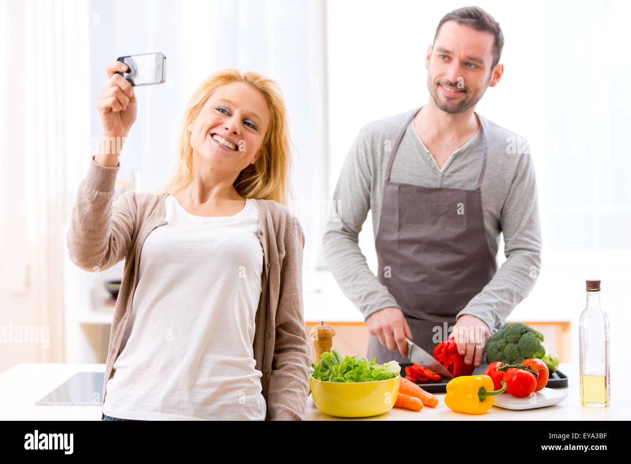 View of a Young attractive woman taking selfie in kitchen Stock Photo