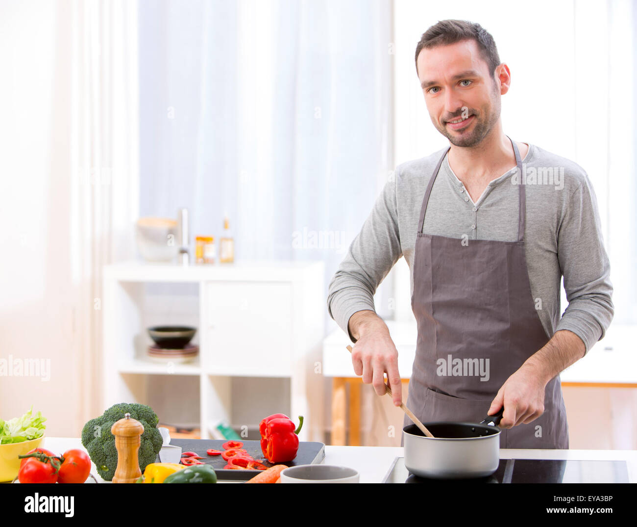 View of a Young attractive man cooking in a kitchen Stock Photo