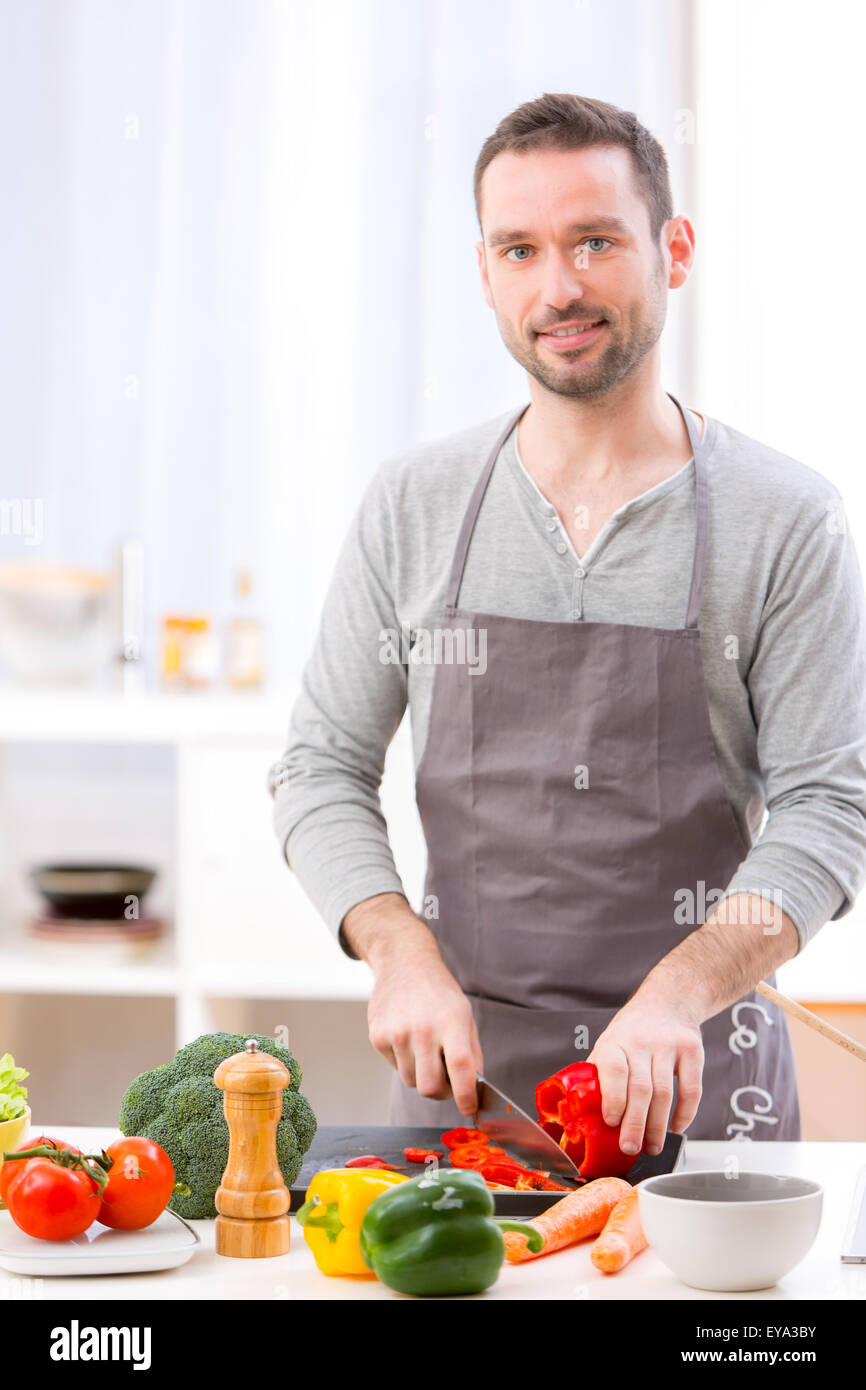 View of a Young attractive man cooking in a kitchen Stock Photo