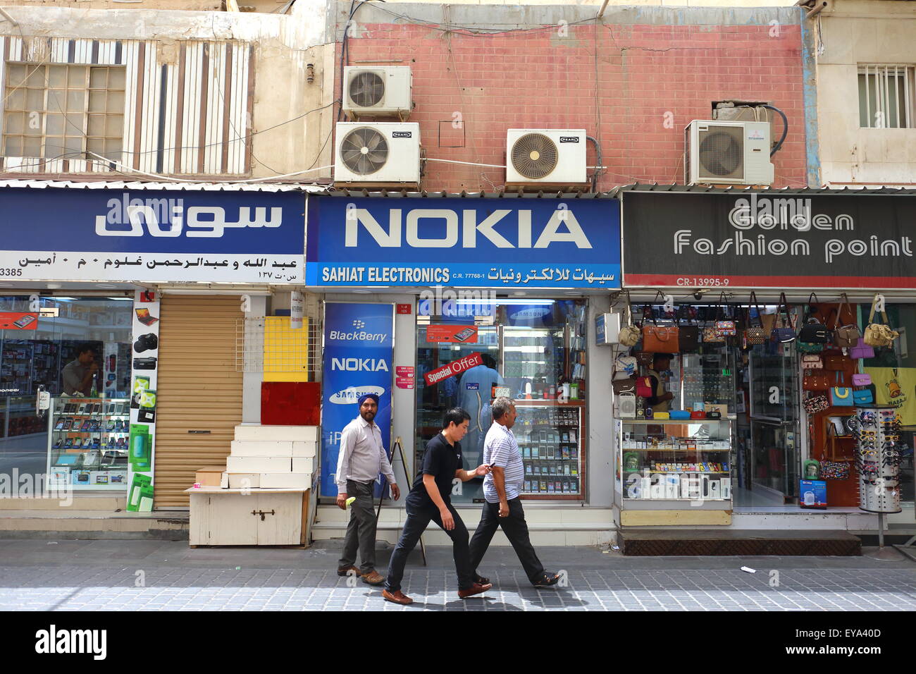 People walking past shops in the Manama souk, Kingdom of Bahrain Stock Photo