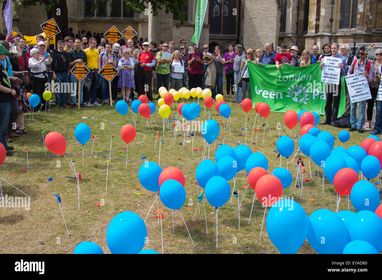 London, UK. 25th July, 2015. Protesters gather outside the Houses of Parliament to demand electoral reform, including proportional representation rather than the first-past-the-post method that saw the Tories gain a majority. PICTURED: Popped ballons representing 'unrepresented' votes stand amongst those still inflated representing parties that succeeded through thye first-past-the-post system. Credit:  Paul Davey/Alamy Live News Stock Photo