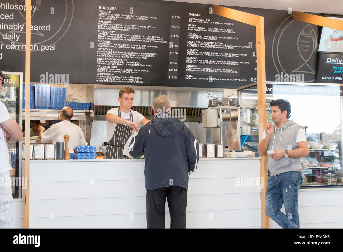 People awaiting their order of takeaway fish and chips or burgers at a sydney fish and chip shop Balmoral Beach,Sydney,Australia Stock Photo