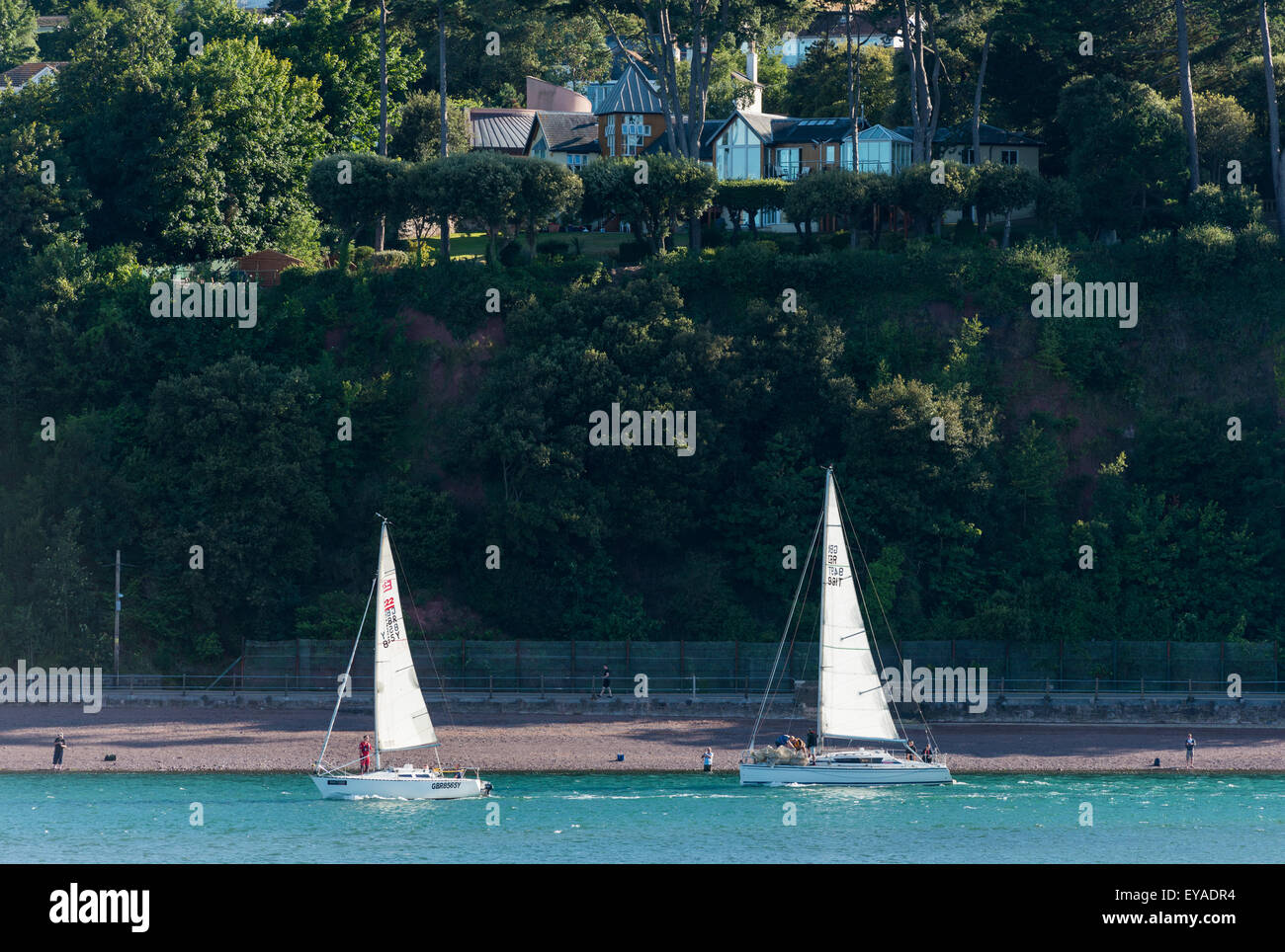 Two yachts head out to sea from the River Teign past Shaldon and some of it's landmarks. Stock Photo
